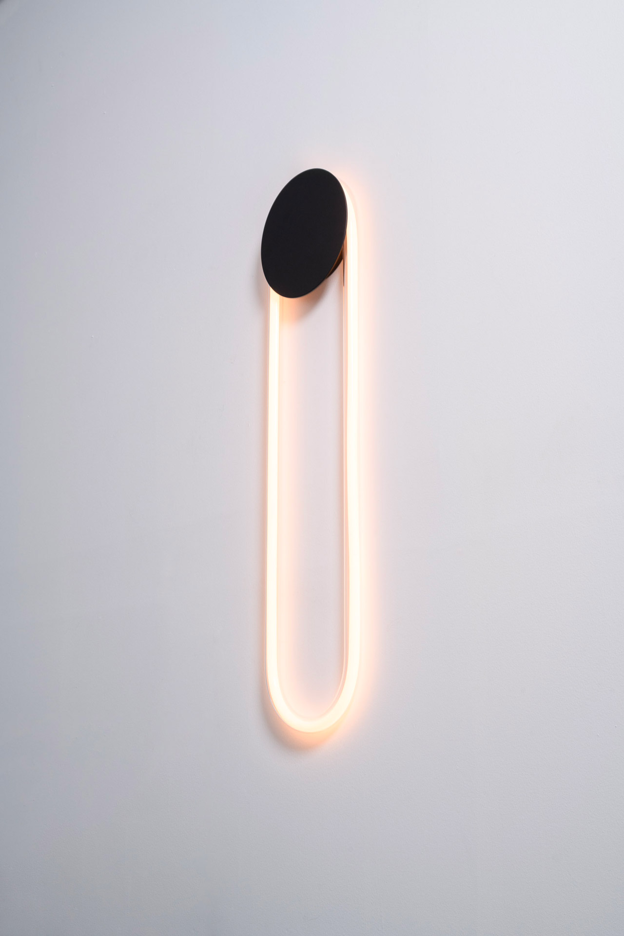 Ra Wall, designed by Alex Joncas, is distinguished by a fascinating duality of strength and delicacy. Like an eclipse, its disk masks a portion of the light while capturing and reflecting the room's nuances.