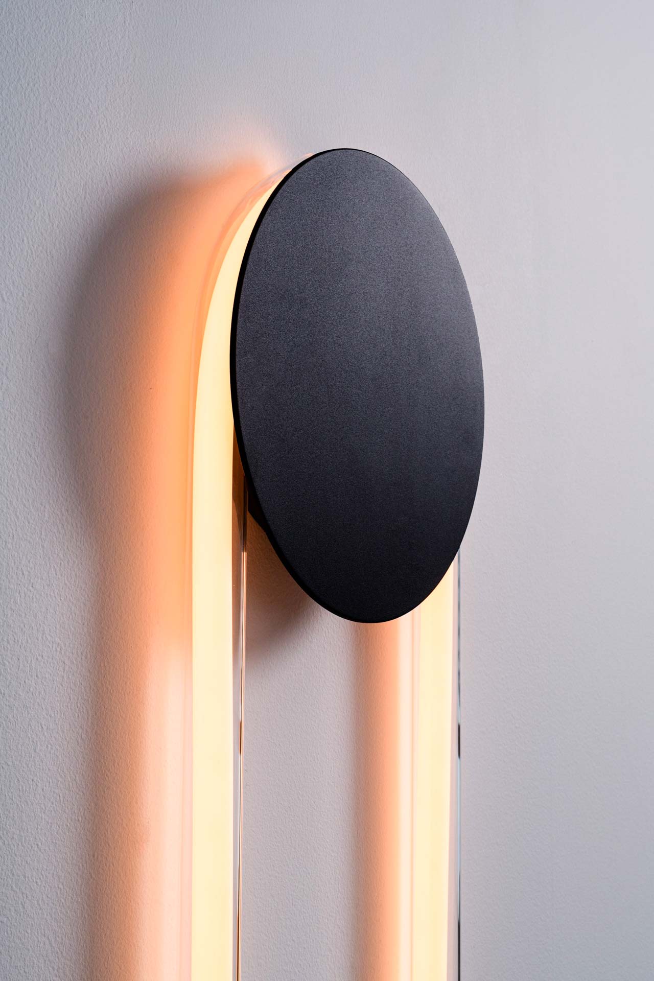 Ra Wall, designed by Alex Joncas, is distinguished by a fascinating duality of strength and delicacy. Like an eclipse, its disk masks a portion of the light while capturing and reflecting the room's nuances.